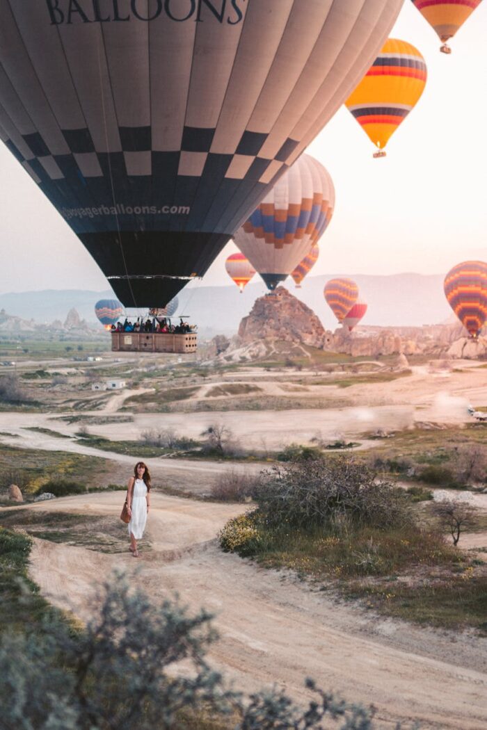 woman standing under hot air balloons
